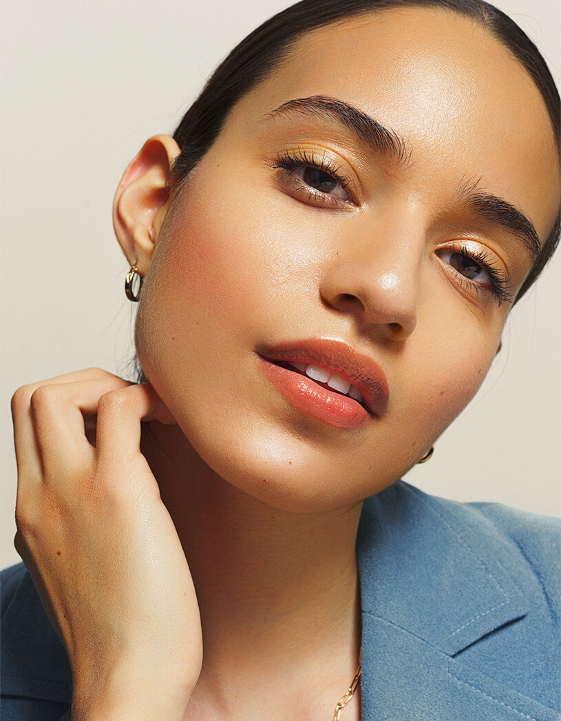 Close-up of a woman with a neutral background and natural brows